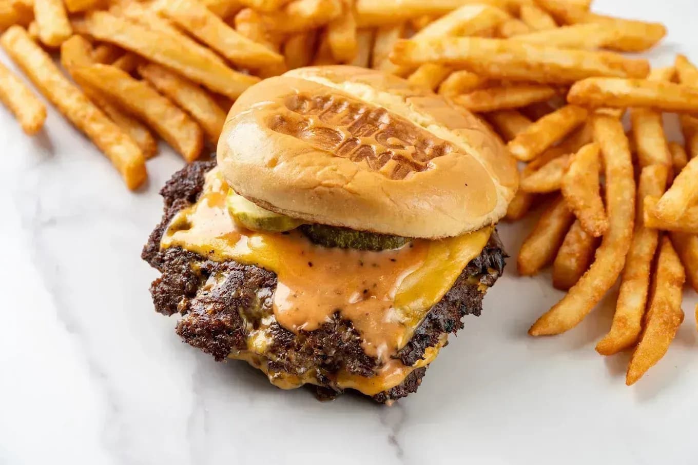 Halal smash burger with fries at Juicy Joint